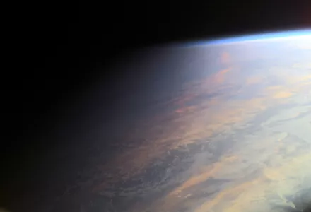 the passage of day into night in this view of ocean and clouds over Earth