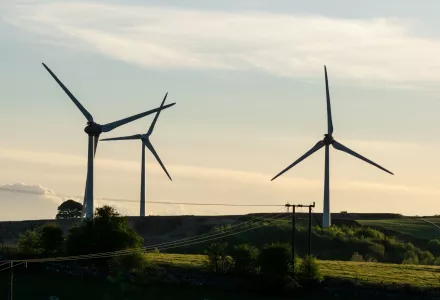 three wind turbines silhouetted against the sky