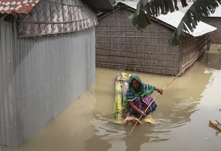 A woman rows a makeshift raft near her partially submerged house in Gagolmari village, Morigaon district, Assam, India, Tuesday, July 14, 2020.