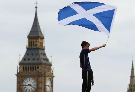 A boy flies a Saltire over the Palace of Westminster