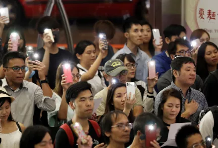 Supporters flash their smartphones lights as they join the protesters singing