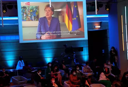 German Chancellor Angela Merkel, on a screen, speaks via videoconference