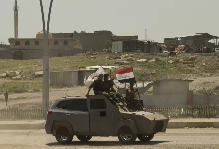 Shiite popular mobilization forces parade with a captured Islamic State vehicle in Mosul