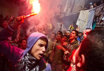 An Egyptian youth carries a lit flare 
