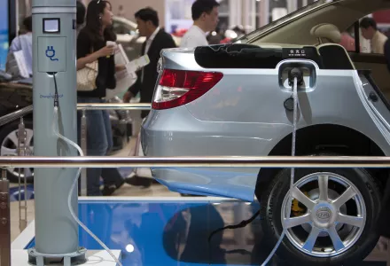 visitors tours the BYD Co. booth displaying an electric vehicle with a charger at the Shanghai International Auto Show