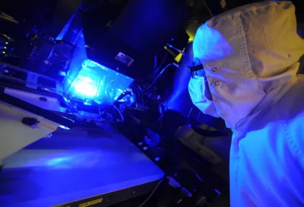 an operator inspects a photolithography tool used to manufacture these solar cells. 