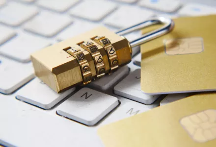A lock on top of a keyboard and credit cards
