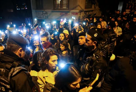 Protesters walk past a police security line