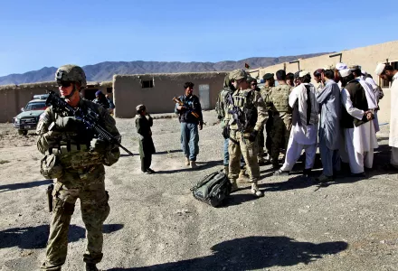 an intelligence officer, helps provide security while Afghan and coalition security force leaders speak with village elders