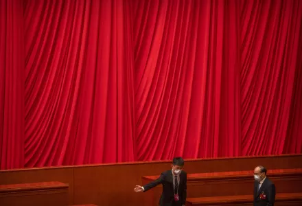 A staff member gestures to a delegate during a session of China's National People's Congress (NPC) at the Great Hall of the People in Beijing, Friday, March 10, 2023.