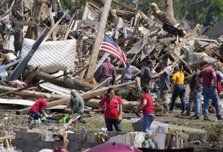 Local residents clean up debris from a tornado damaged home, Wednesday, May 22, 2024, in Greenfield, Iowa. (AP Photo/Charlie Neibergall)
