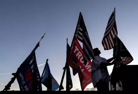 Nikki Fuller, 56, sets up flags on her truck near the Mar-a-Lago estate of President-elect Donald Trump, Monday, Nov. 11, 2024, in Palm Beach, Fla. (AP Photo/Julia Demaree Nikhinson)