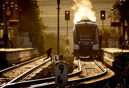 A man runs over rails to reach a regional hydrogen train in the station of Wehrheim, near Frankfurt, Germany, early Monday, Aug. 26, 2024.