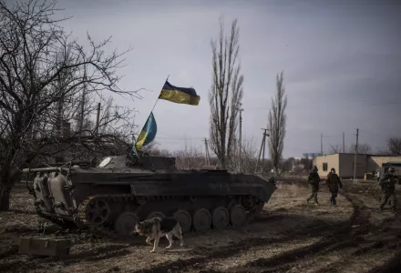 A stray dog runs past a Ukrainian military vehicle near Debaltseve, eastern Ukraine, Sunday, Feb. 8, 2015. The government-held town of Debaltseve, a key railway junction, has been the epicenter of recent battles between Russian-backed separatists and Ukrainian government troops. For two weeks, the town has been pounded by intense shelling that knocked out power, heat and running water in the dead of winter.