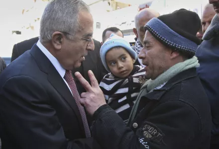 Palestinian Prime Minister Salam Fayyad, left, talks to a man during a visit to the West Bank city of Nablus. Saturday, Feb. 4 , 2012.