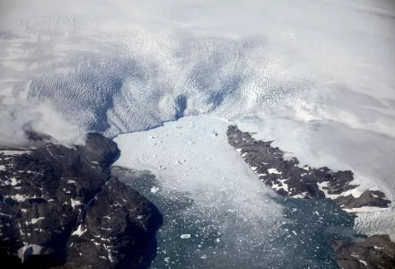 a glacier calves icebergs into a fjord off the Greenland ice sheet