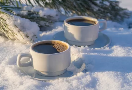 Two coffee cups in the snow.
