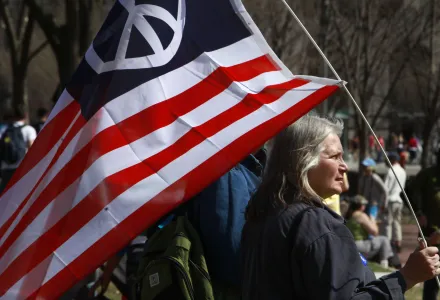 Peace activist Marilyn Cornell, of Strongsville, Ohio, holds an American flag with a peace sign on it during an anti-war protest in Washington, on Saturday, March 20, 2010. 