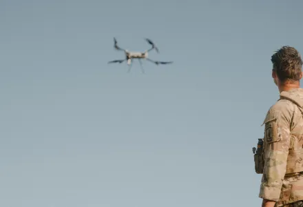 A soldier looks at a drone.