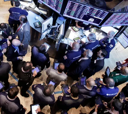 A group of workers gathered around monitors