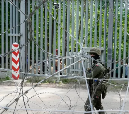 A soldier standing guard behind a fence