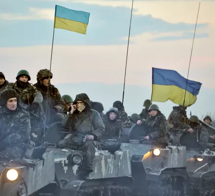 Ukrainian Soldiers on their Tanks showing the Ukrainian Flag.