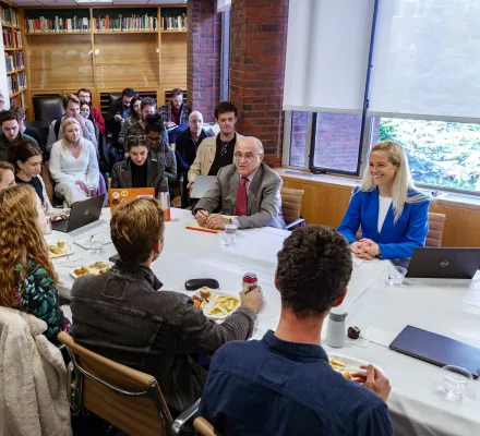 Halla Hrund Logadóttir and Henry Lee sit at a conference table with students.