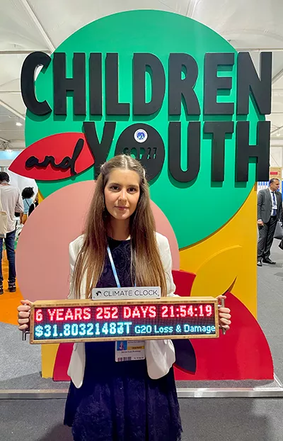 Renata Koch Alvarenga holds the Climate Clock at the COP27 Children and Youth Pavilion, displaying the world's remaining carbon budget.