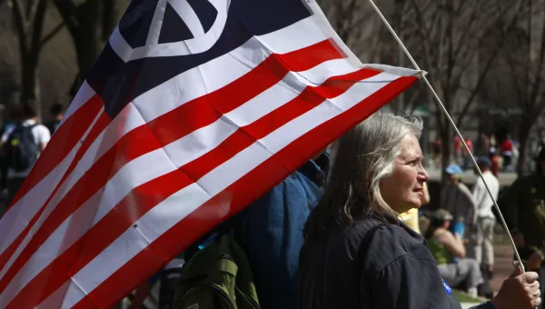Peace activist Marilyn Cornell, of Strongsville, Ohio, holds an American flag with a peace sign on it during an anti-war protest in Washington, on Saturday, March 20, 2010. 