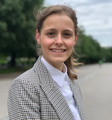 Woman in a suit faces the camera, smiling