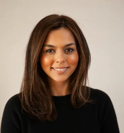 Woman in a black top faces the camera, smiling.